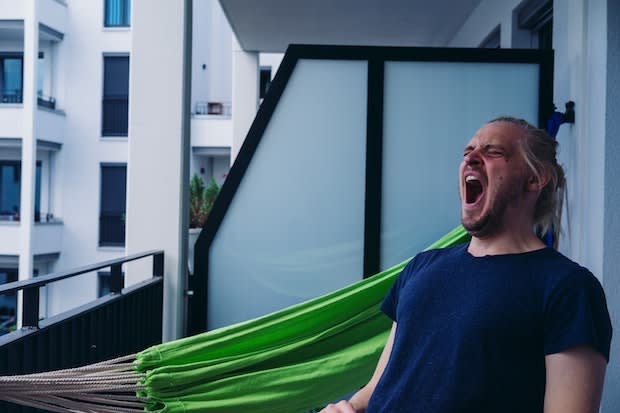 a man yawning on his balcony