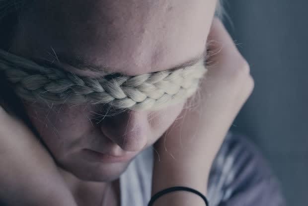 an adolescent girl covering her face with her hair