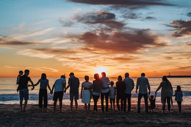 a big group of family members on a beach