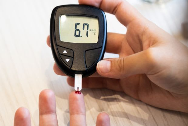 man measuring his blood sugar levels