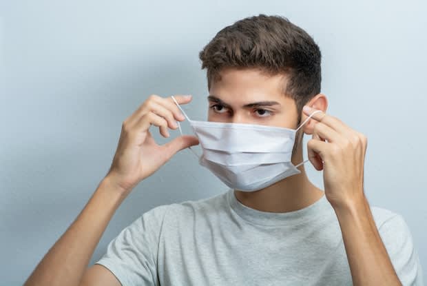 a person putting on a medical mask