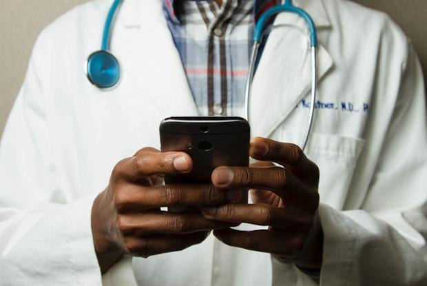 a doctor looking down at a cellphone