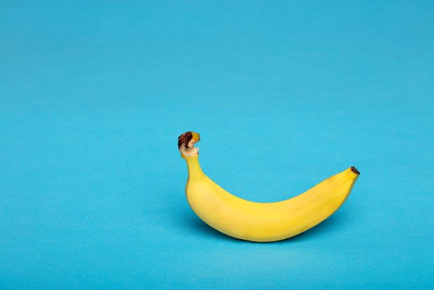 a single banana on a blue background