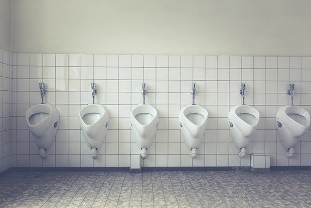 urinals lined up on the wall