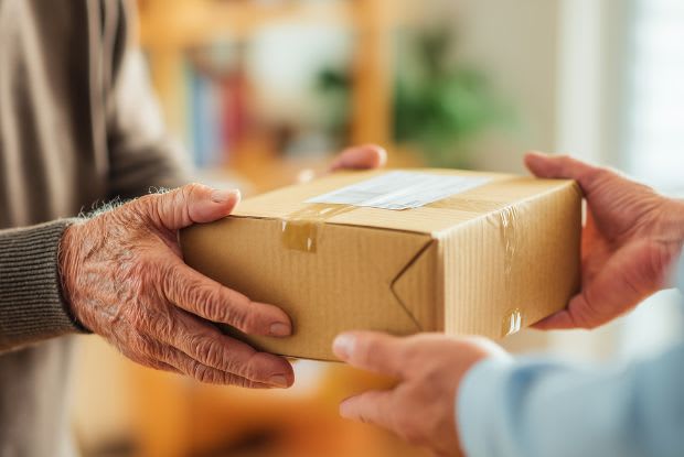An elderly man accepting a pharmacy prescription delivery