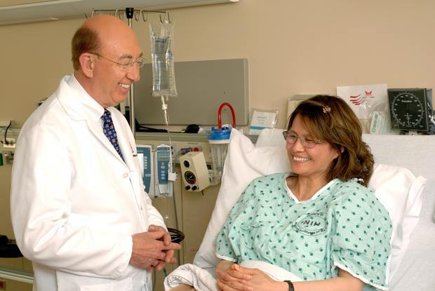 a doctor talking to a patient who is lying in a hospital bed