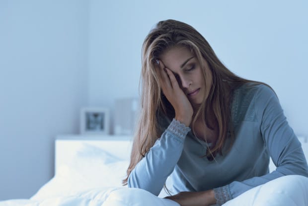 a woman in bed displaying signs of fatigue