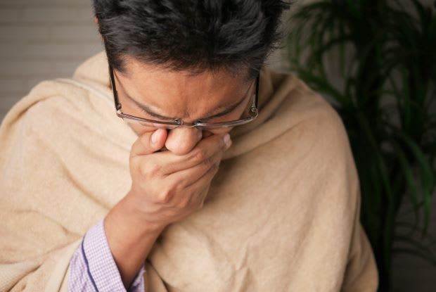 a man coughing into his hand