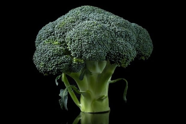 a head of broccoli on a black background