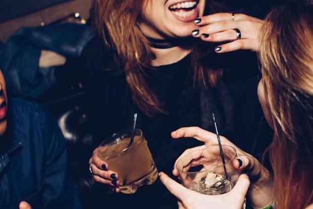 two girls holding alcoholic drinks