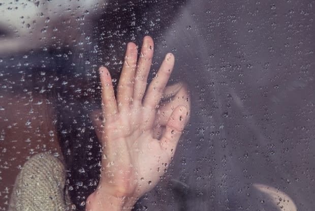 a person looking outside a rainy window