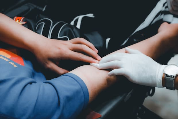 A person taking a blood sample out of someone’s arm