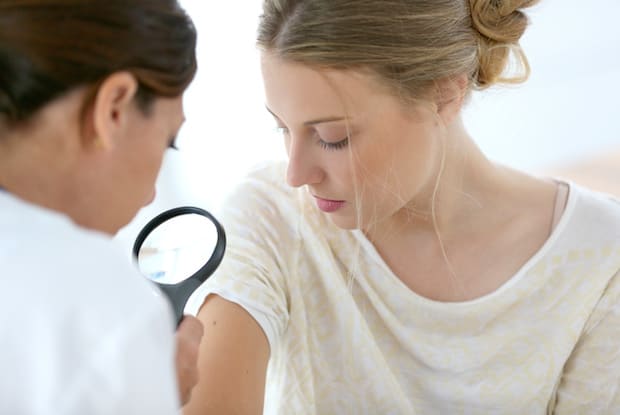 a dermatologist looking at a person