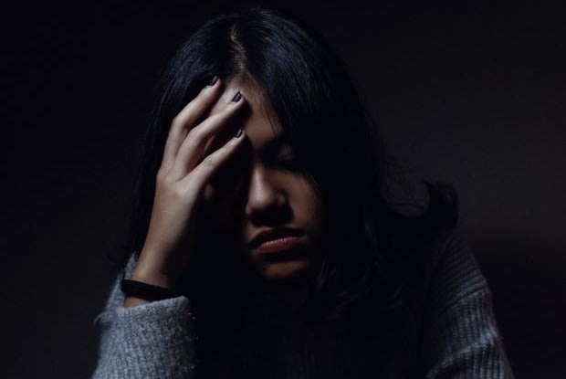 a woman holding her head in pain