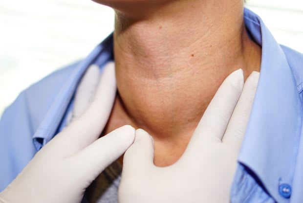 a doctor examining a person’s goiter