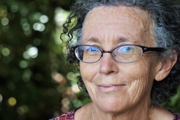 an older woman with curly hair and glasses