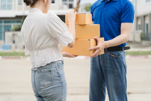 a delivery man handing over a few discreetly packaged boxes to the recipient