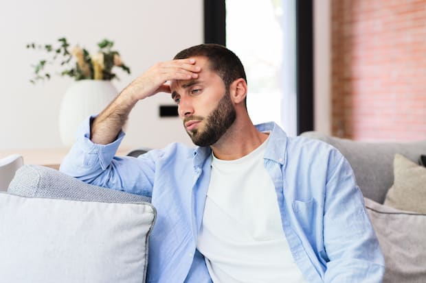 a frustrated man sitting on the couch
