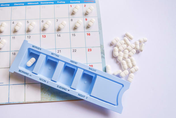 a medication planner on top of a calendar