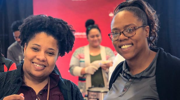 Three smiling african american women at an event