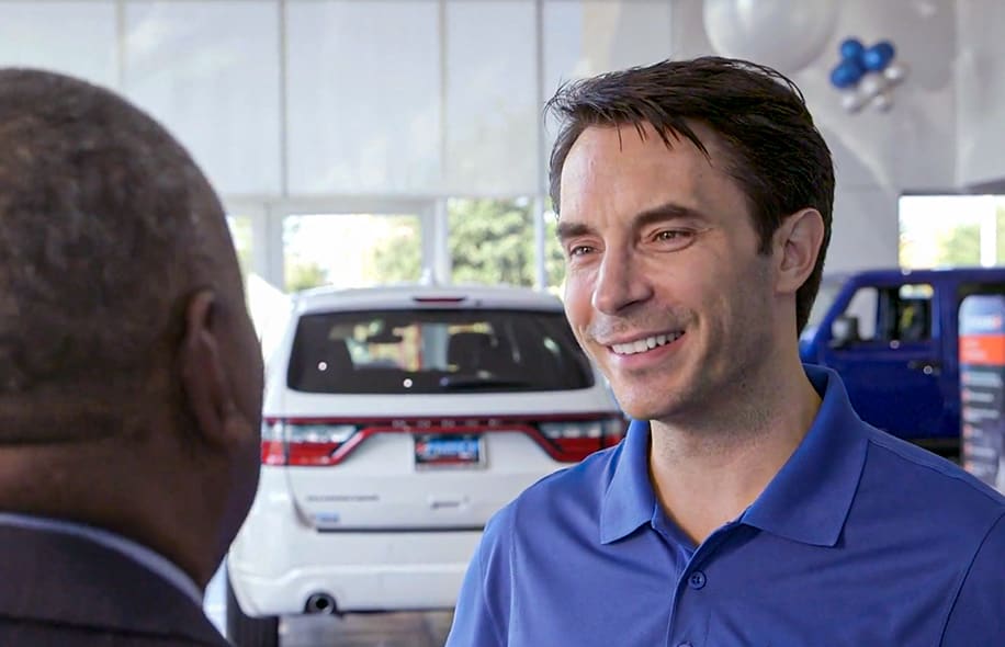 Smiling dealer talking to a Santander Consumer sales rep