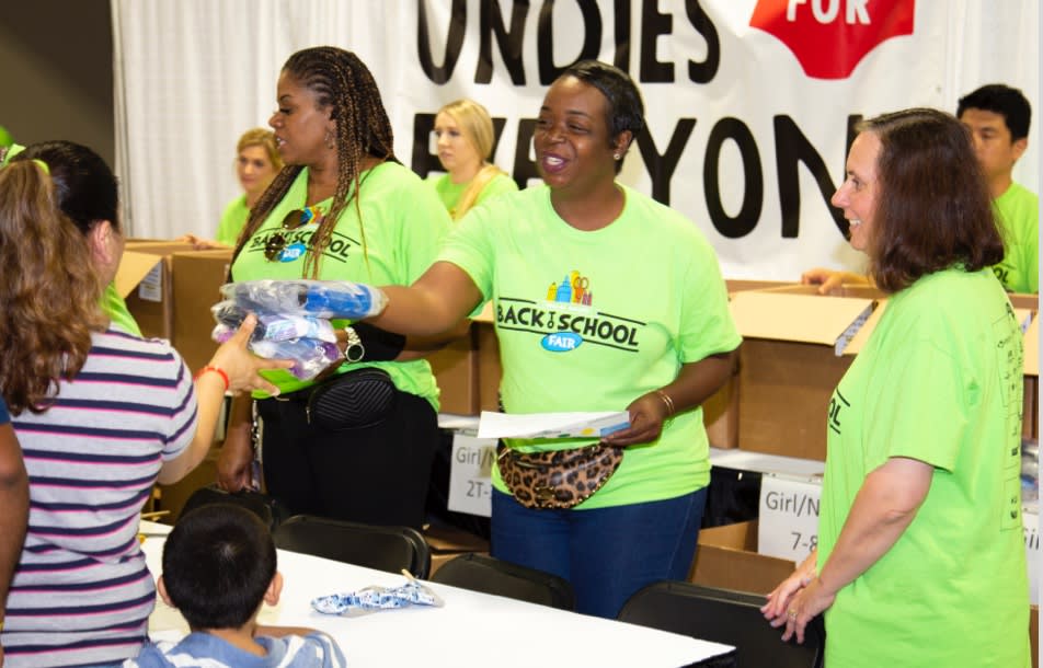Santander Consumer employees hand out supplies to students at a Back to School event