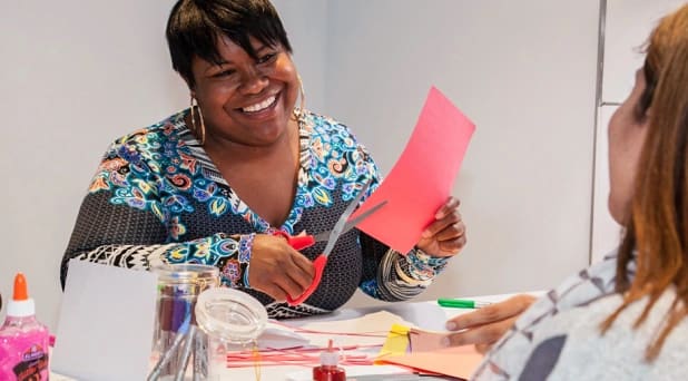 A smiling african american woman is working on a craft project