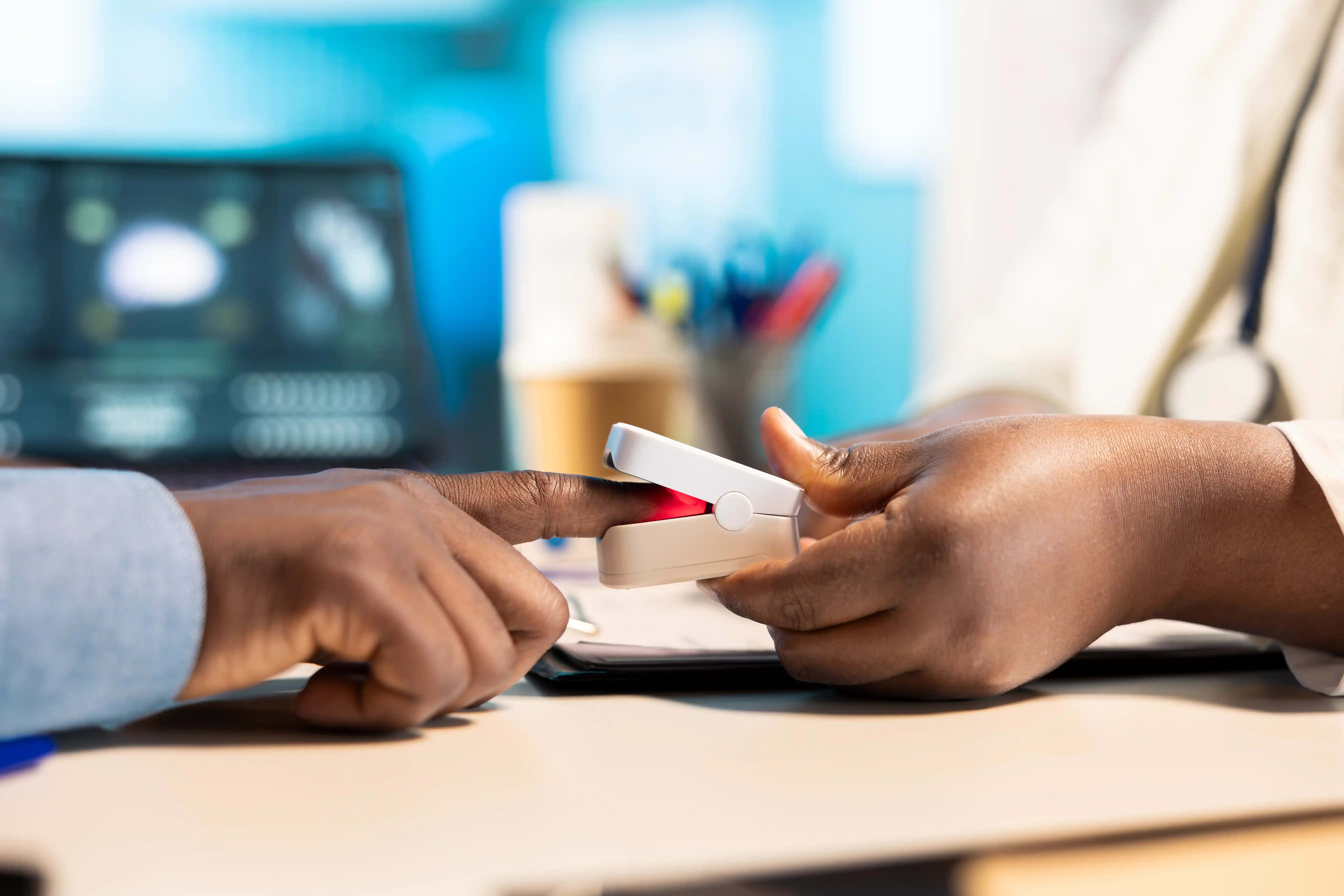 Healthcare professional using a pulse oximeter with a patient