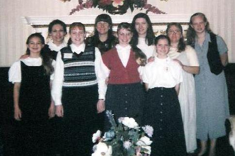 Jessica Steele is in the front wearing a striped sweater vest. Mrs. Steele and I are next to each other on the back row, directly under the flower arrangement on the wall.