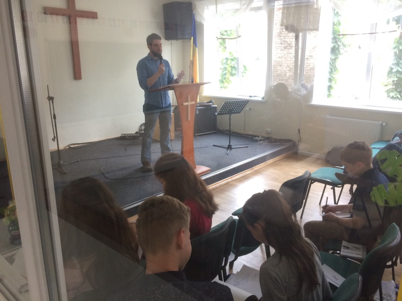 The kids takes notes while listening to a message in the main service.