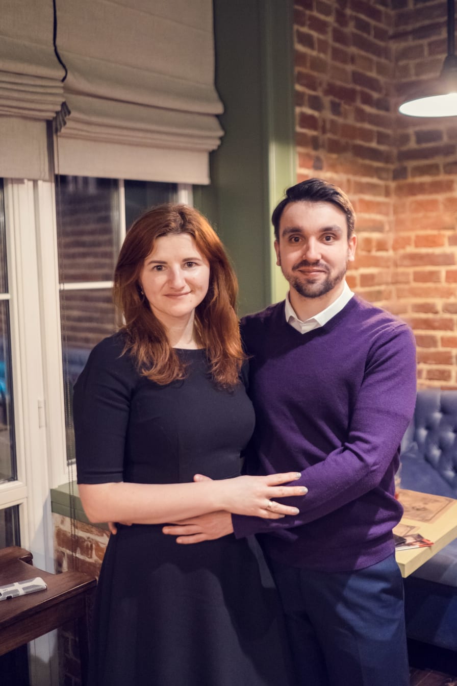 Joshua and Kelsie Steele standing arm in arm by a window at the cafe