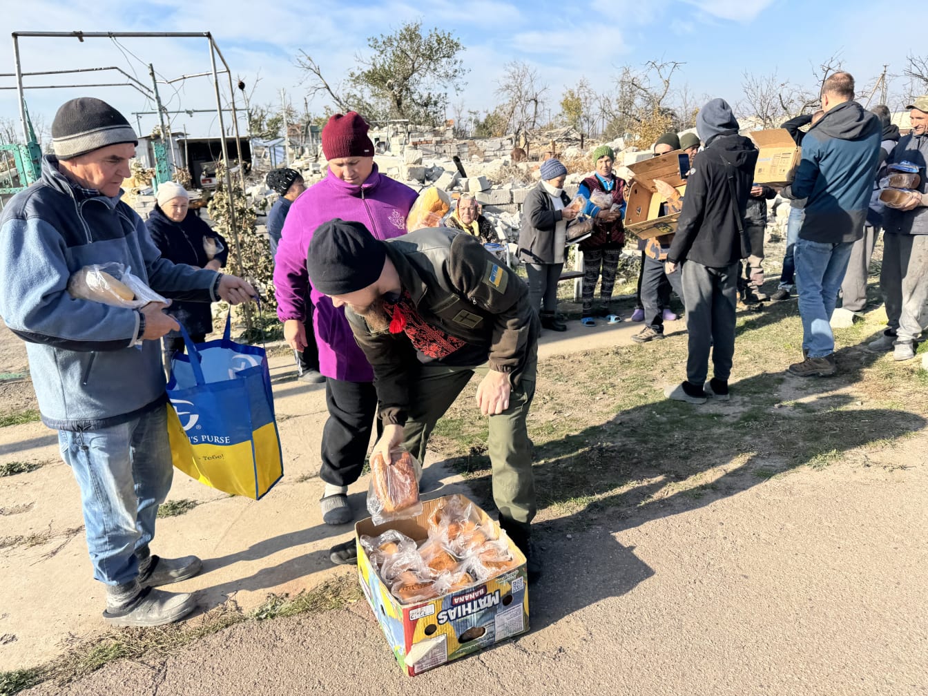 Oleksandr distributes fresh bread amid the rubble of a de-occupied village in southern Ukraine.