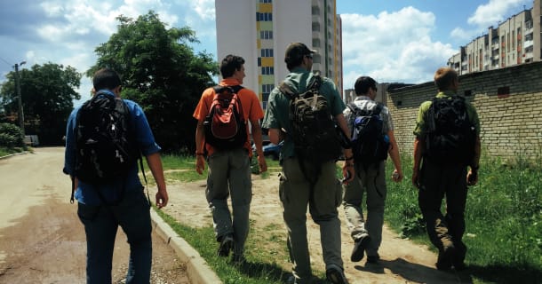 Several of the CMO 2015 team hike towards a new set of buildings during a literature campaign.