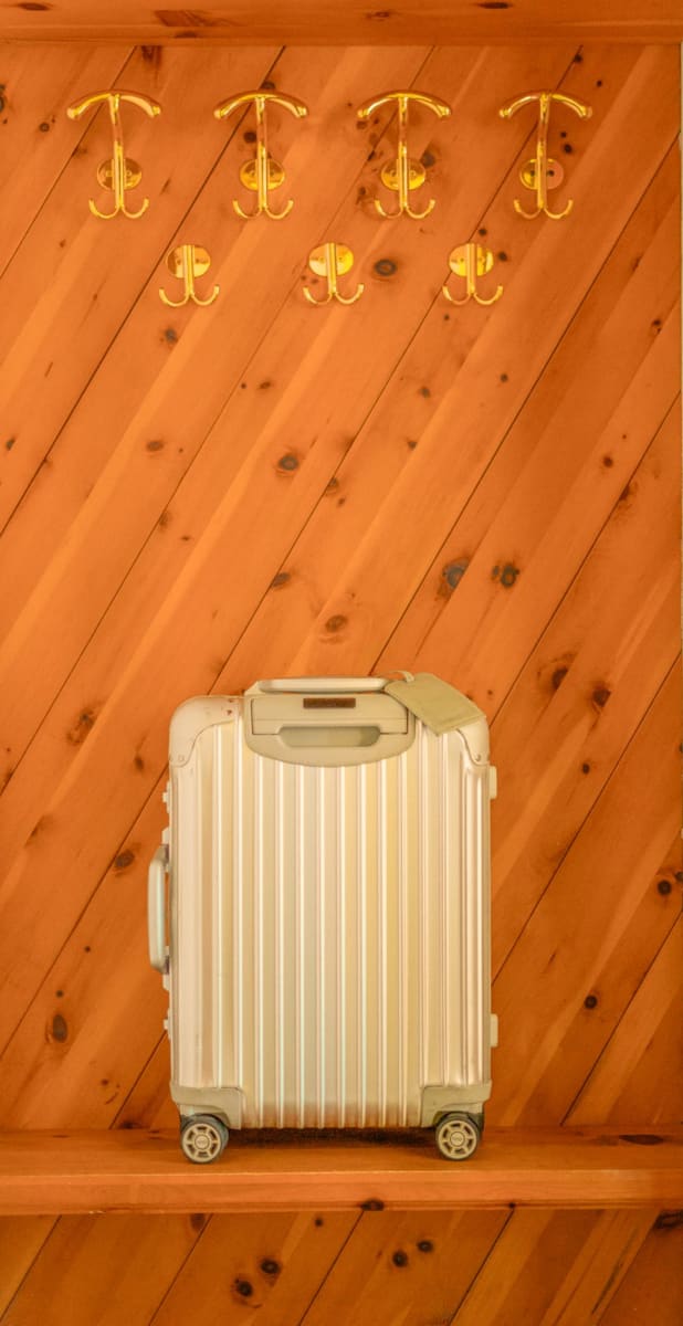 A suitcase is on a shelf in front of a wooden wall in the Glemmtal.