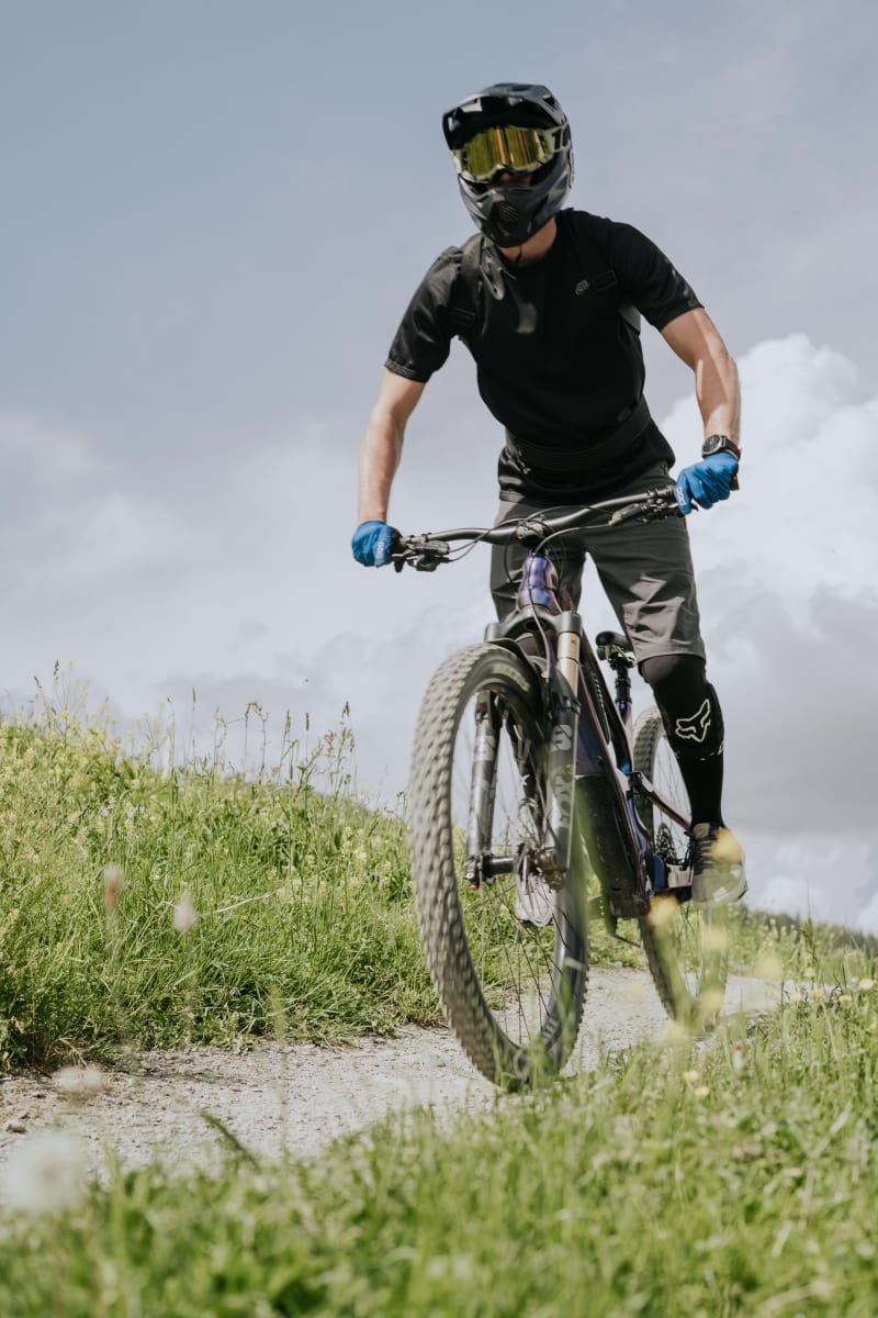 A mountain biker rides on a path in the Glemmtal. The green landscape is stunning.