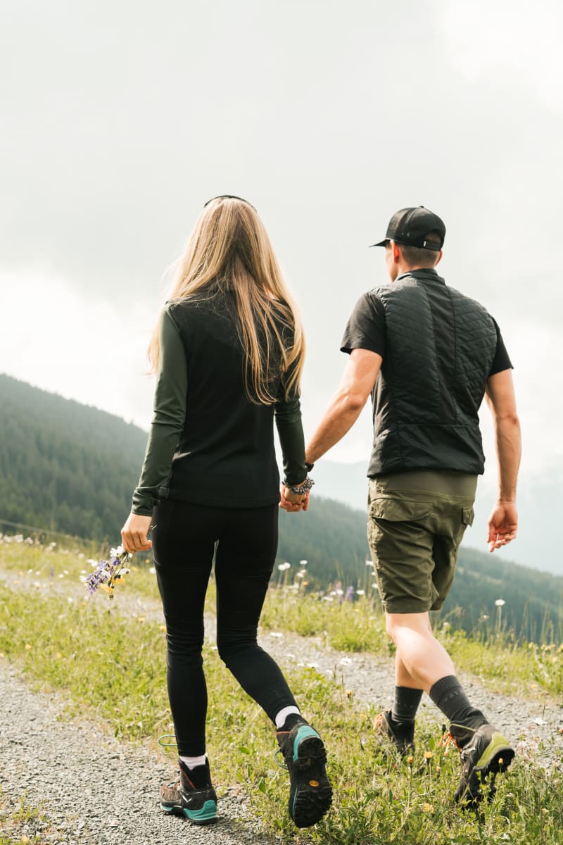 Ein Paar hält Händchen und wandert im Glemmtal auf einem Weg.