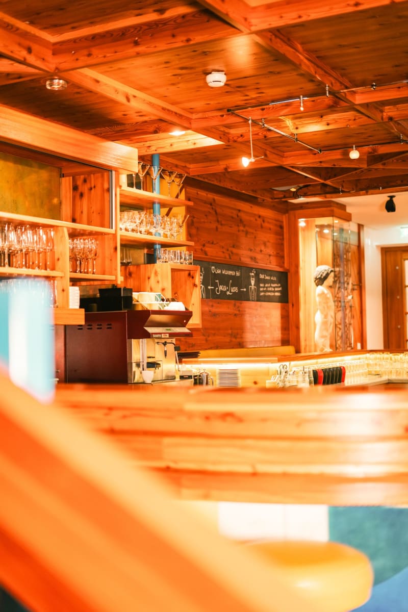 A cozy bar area in Glemmtalerhof in Hinterglemm. Wooden decor and glasses await guests.
