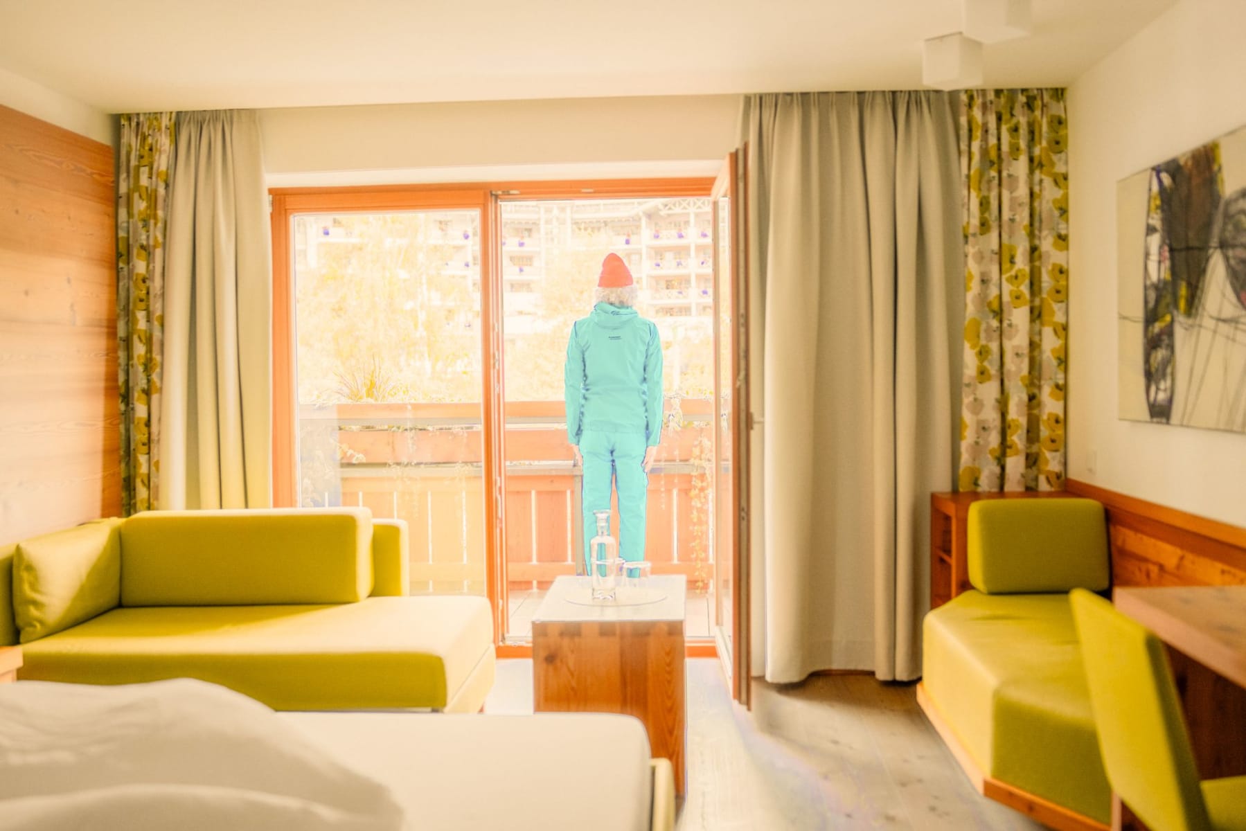 A man in winter clothing stands on the balcony of the Glemmtalerhof in Hinterglemm.