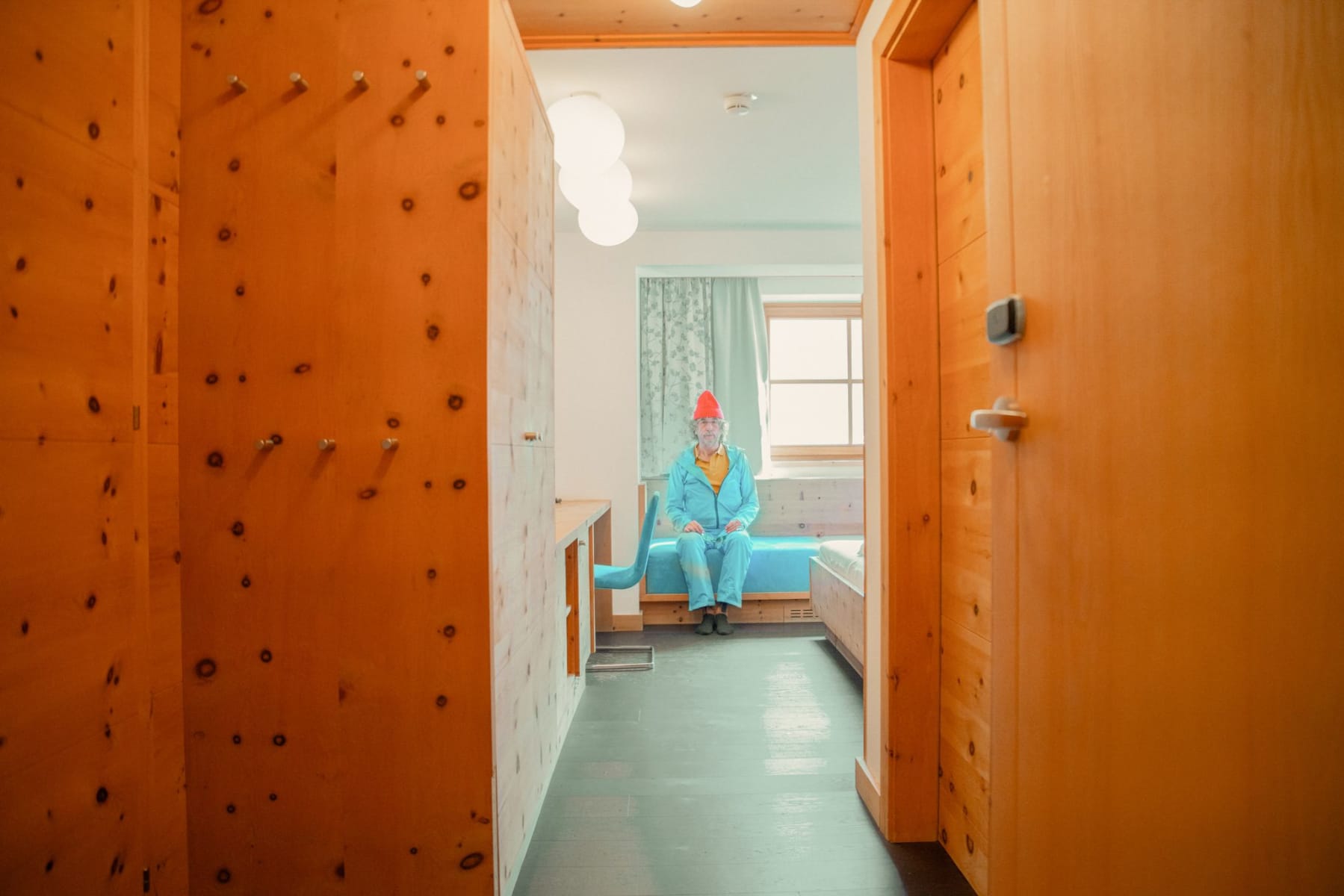 A cozy room in Glemmtalerhof in Hinterglemm with wooden details and a man in blue clothing.