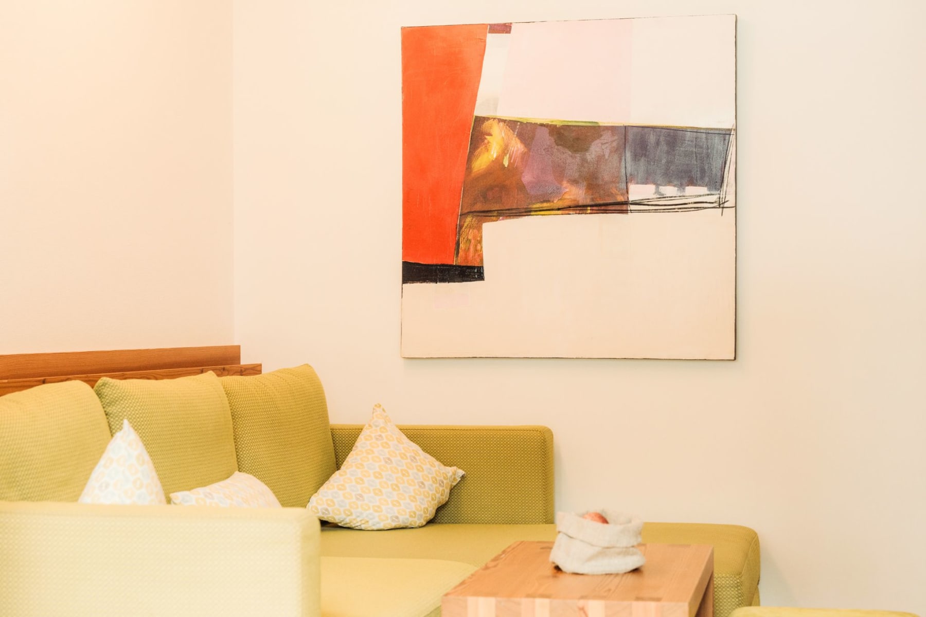 A cozy living area with a colorful painting and an inviting couch in the Glemmtalerhof in