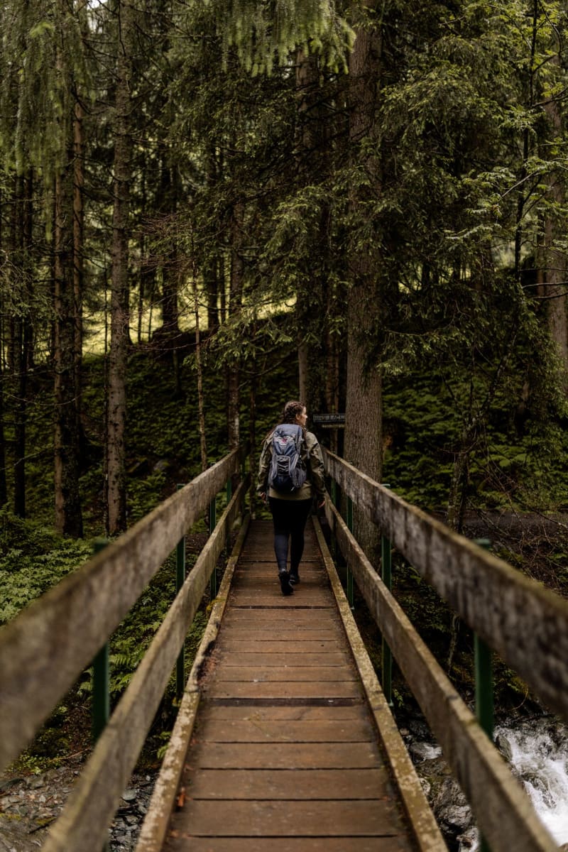 Durch den Wald wandernd auf einer Brücke, umgeben von Natur und dem Glemmtal.