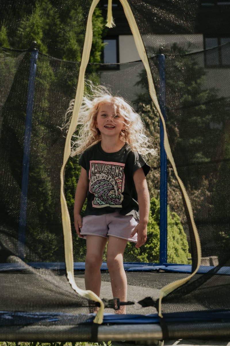 Ein fröhliches Kind springt auf einem Trampolin im Glemmtal.