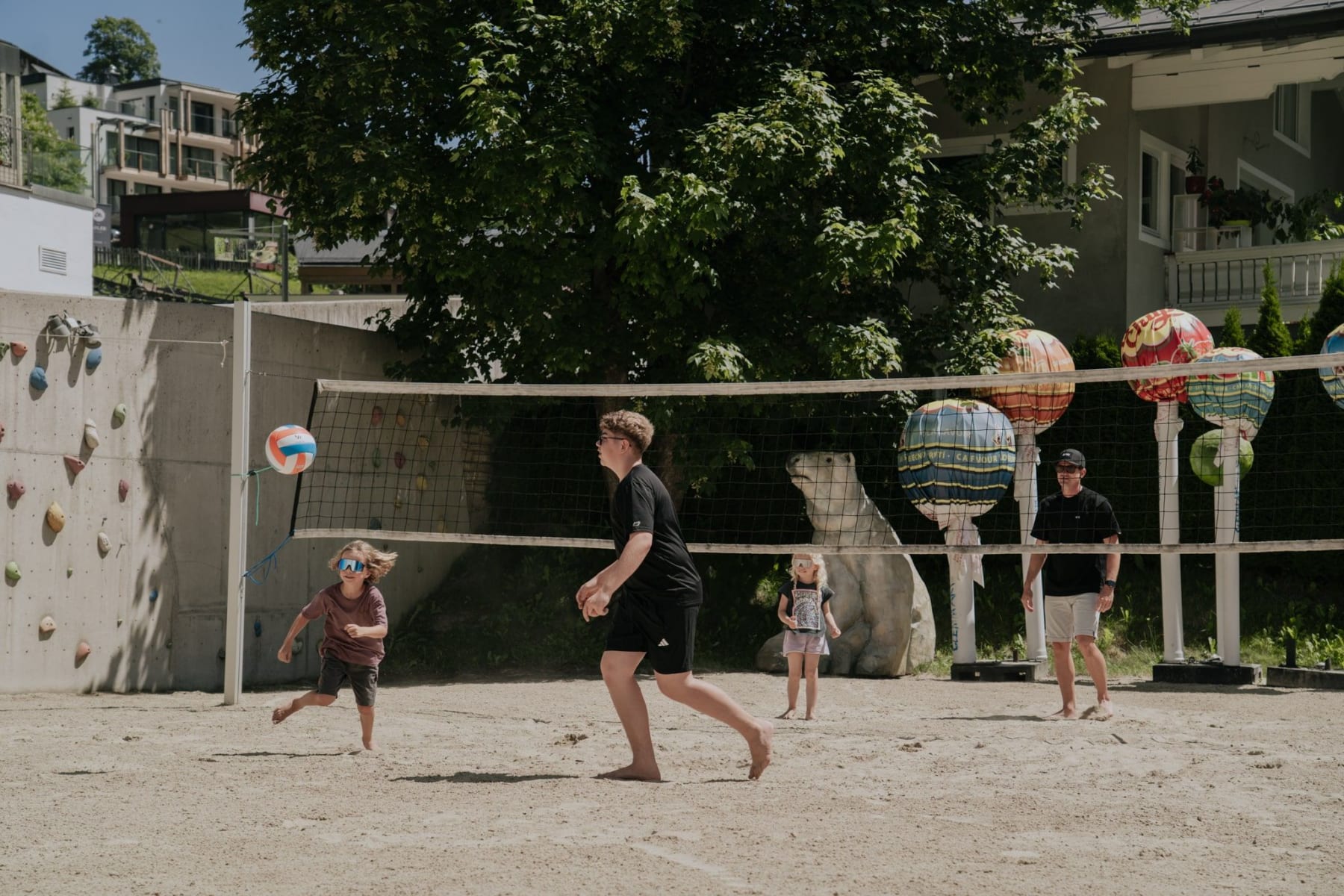 Kinder spielen Volleyball am Glemmtalerhof in Hinterglemm bei sonnigem Wetter.