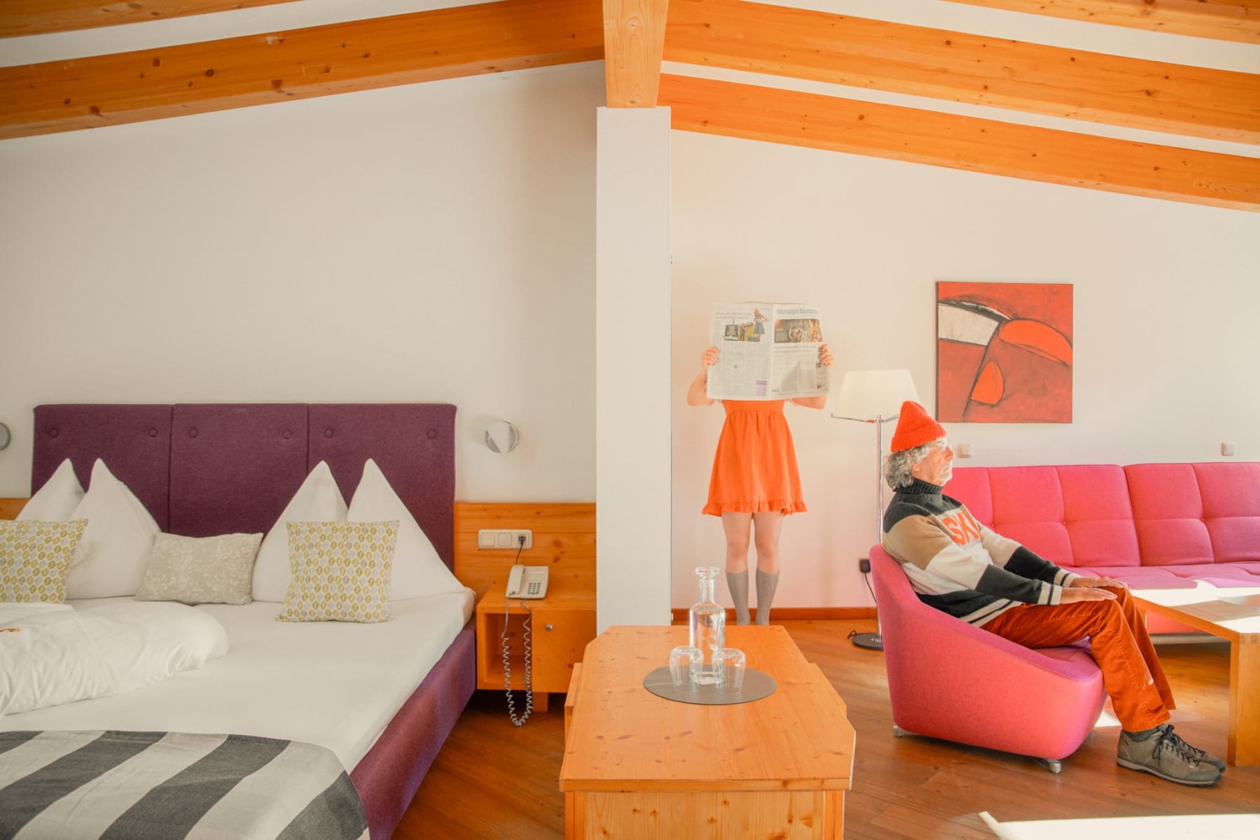 Glemmtalerhof in Hinterglemm, modern room, vibrant colors, person with newspaper and someone