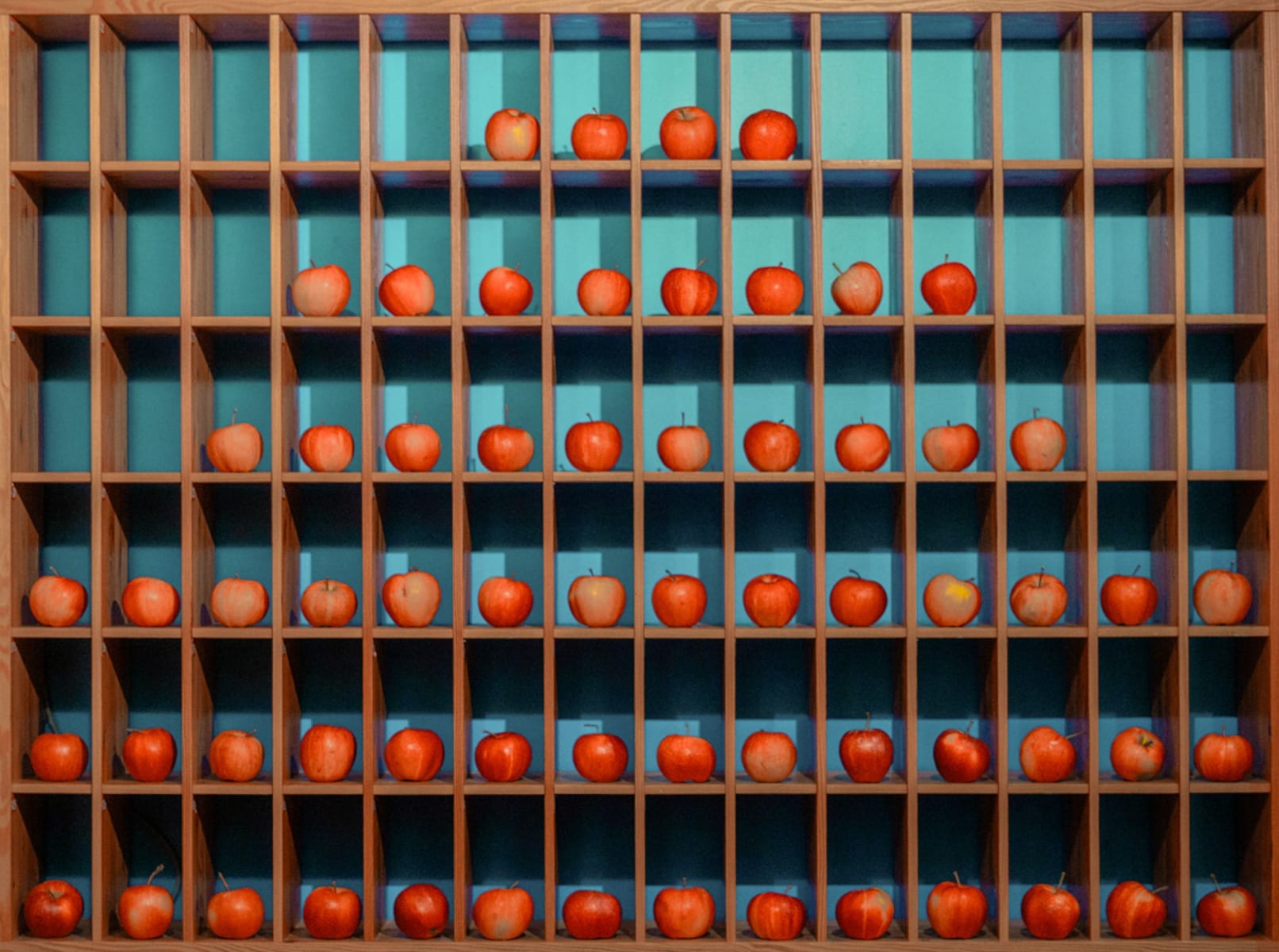 Apples arranged in shelves in a stylish room reminiscent of the Glemmtalerhof in Hinterglemm.