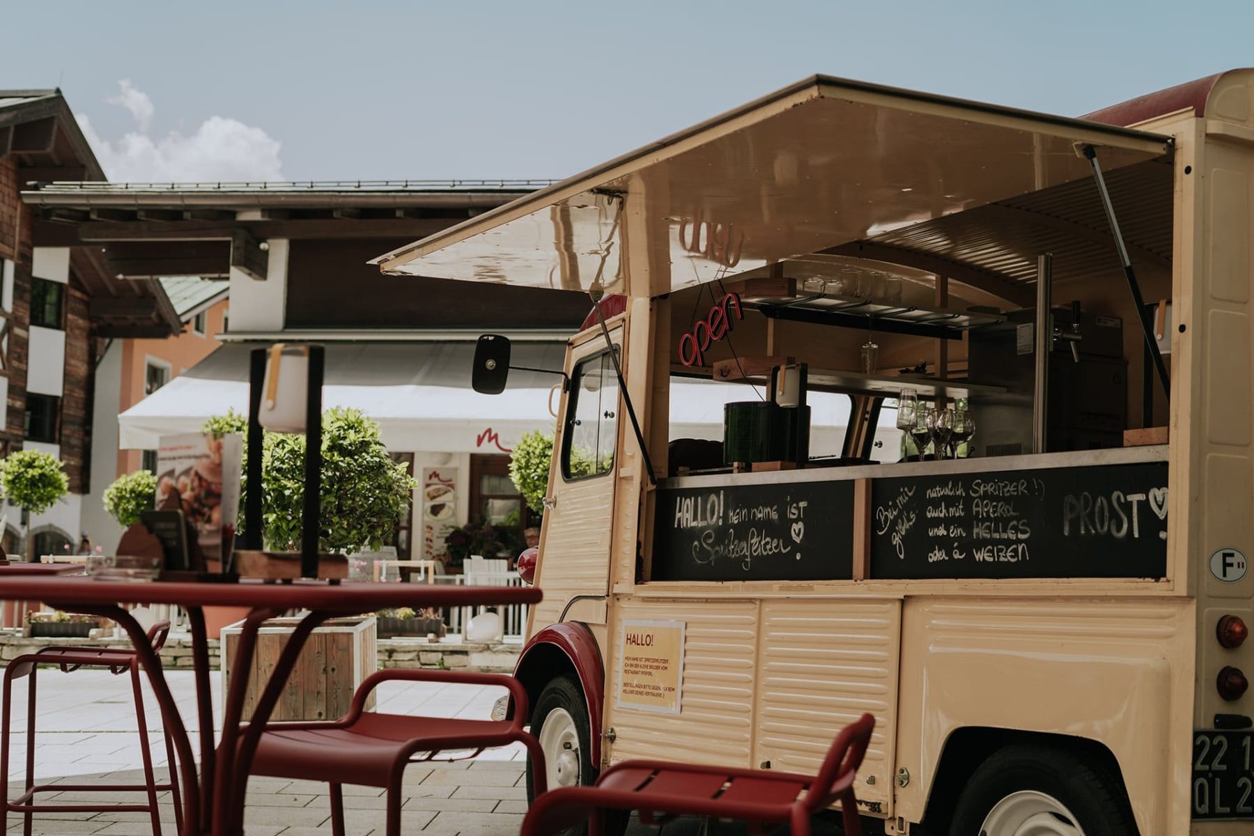 Im Glemmtal steht ein Foodtruck mit freundlichem Angebot und einladenden Tischen.