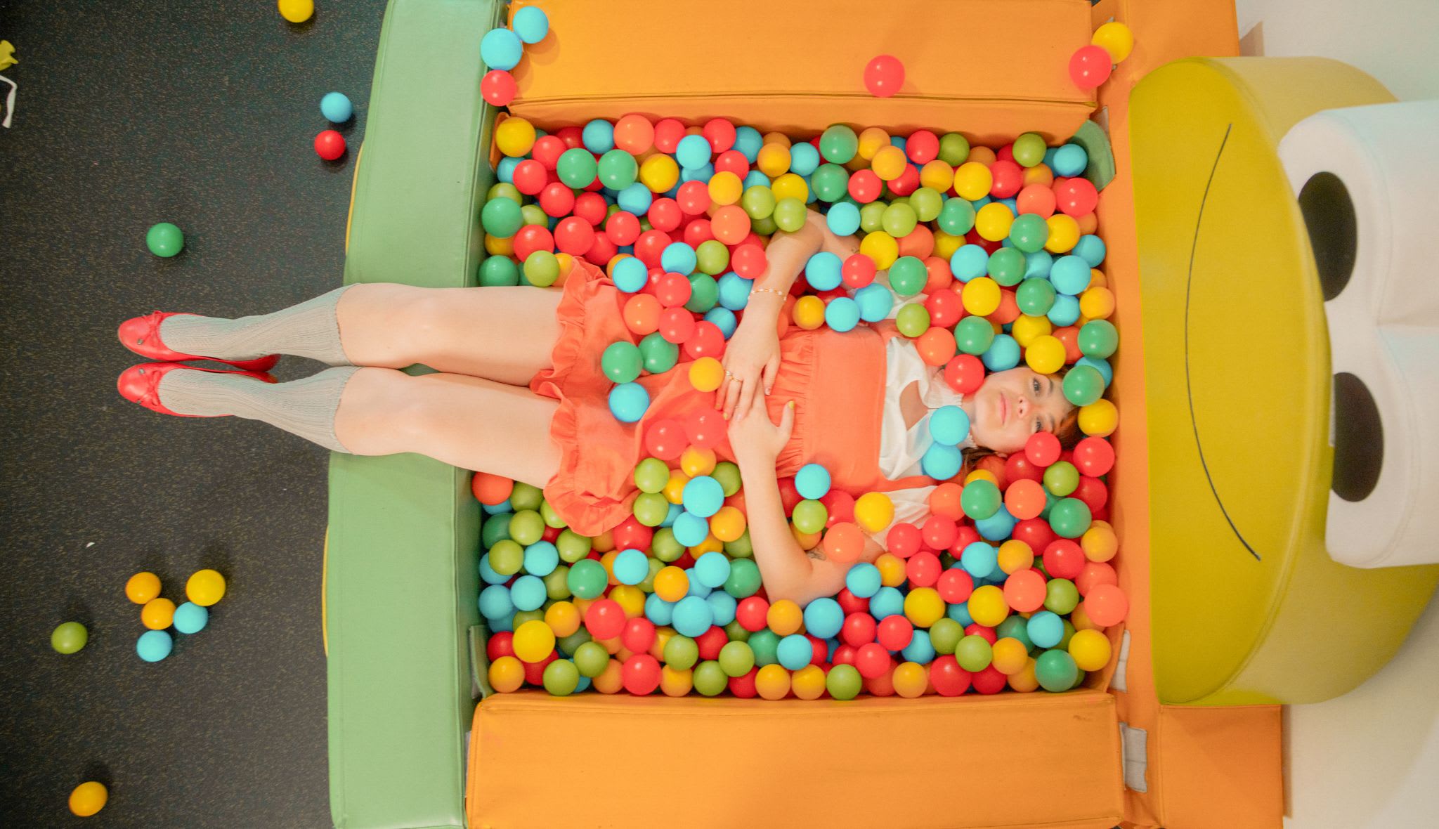 A child is lying in a pool of colorful balls at the Glemmtalerhof in Hinterglemm.
