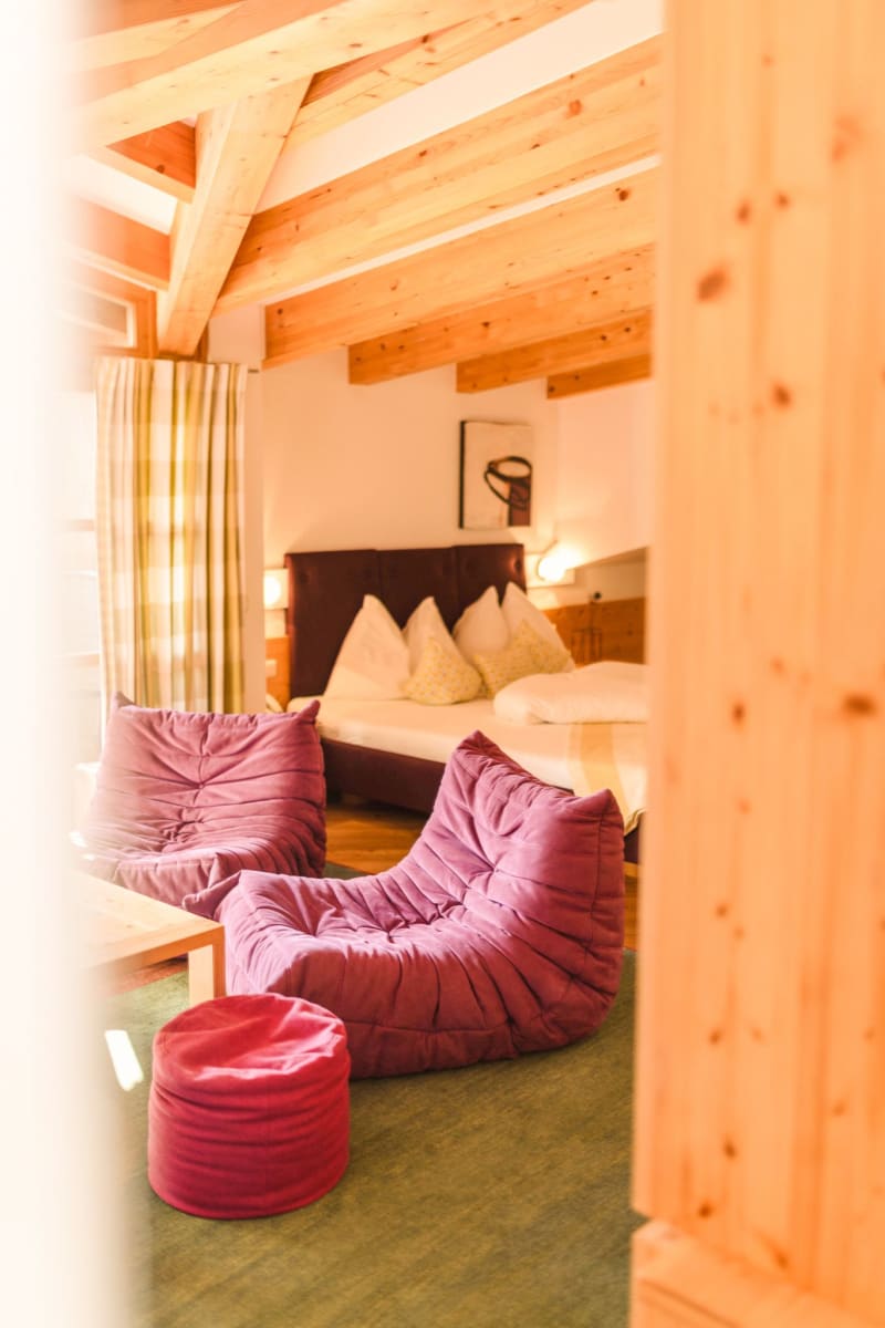 Cozy room in Glemmtalerhof with wooden ceiling and purple furniture.