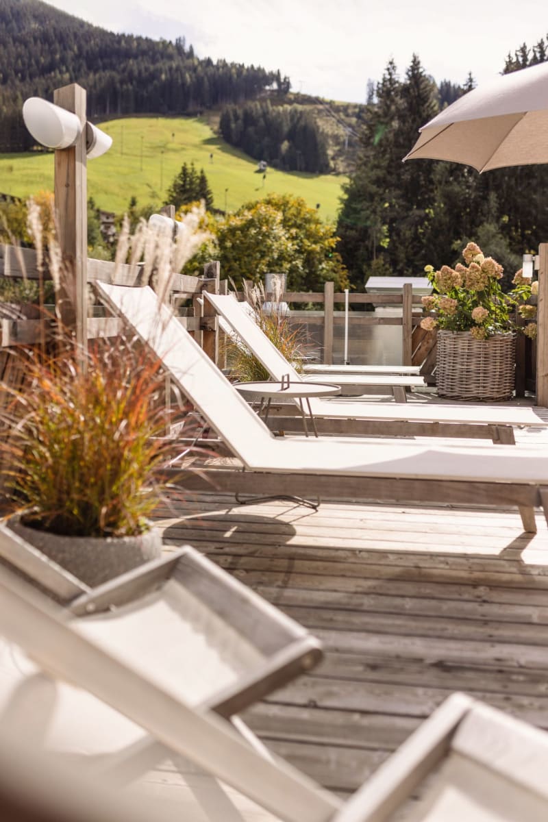 Relaxing atmosphere with loungers and a view of the green landscape of Hinterglemm.
