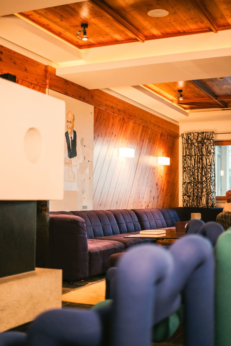 Modern room with purple sofa and wood paneling in the Glemmtalerhof in Hinterglemm.